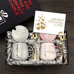 two coffee mugs in a gift box with gold spoons and a note card