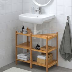 a bathroom with a sink, towel rack and towels on the shelf next to it