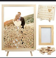 a wooden photo frame with hearts on it next to a couple's wedding guest book