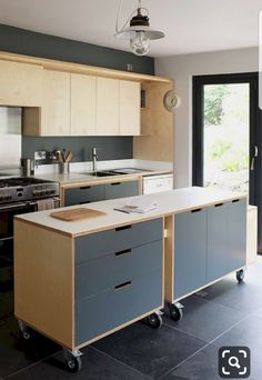 a kitchen with an island, sink and stove in it's center area next to a sliding glass door