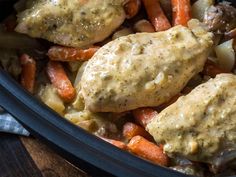 chicken and carrots with gravy in a crock pot on a wooden table