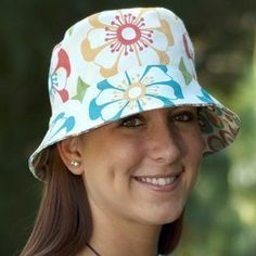 a woman wearing a white hat with colorful flowers on it and the words women's day written in front of her