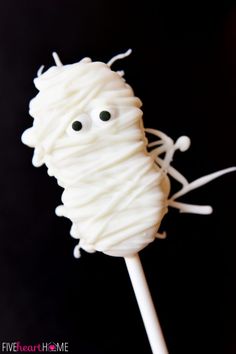 a close up of a cake on a stick with eyes