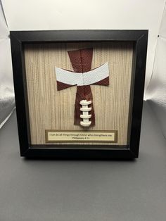 a football in a shadow box with a ribbon