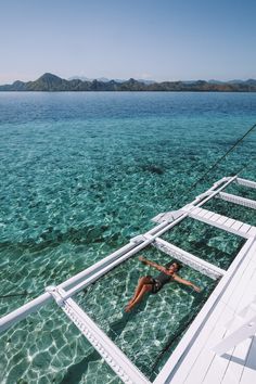 a woman floating in the water on top of a boat