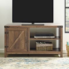 a flat screen tv sitting on top of a wooden entertainment center next to a window