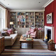 a living room filled with furniture and bookshelves next to a fire place in front of a window