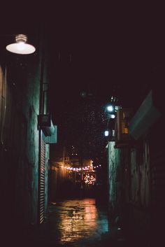 a dark alley way with lights on the street