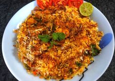 a white plate topped with rice and veggies next to a slice of lime