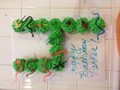 a birthday cake made to look like the letter h with green icing and decorations