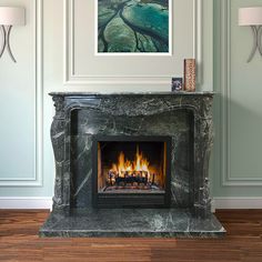 a fire place with a painting on the wall