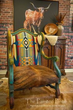 a chair that is sitting in front of a painting on the wall with an animal painted on it