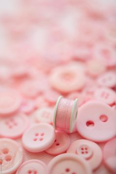 pink buttons and spools are on the table