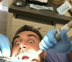 a man is getting his teeth brushed by an electric toothbrush in the dentist's office