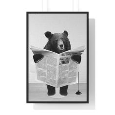 a black and white photo of a bear reading a newspaper