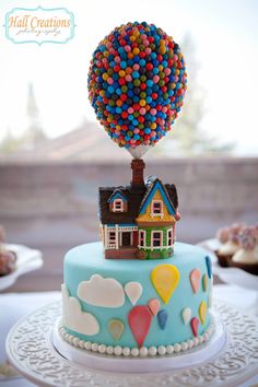 a cake decorated with houses and balloons