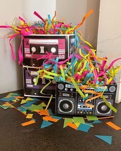 an old school boombox with confetti and streamers on the floor next to it