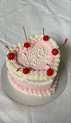 a heart shaped birthday cake with cherries on top and the words happy birthday written in frosting