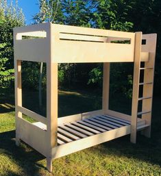 a wooden bunk bed sitting in the grass