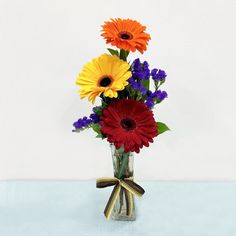 a vase filled with colorful flowers on top of a table