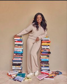 a woman standing in front of a stack of books