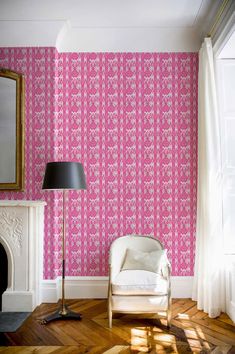 a living room with pink wallpaper and a white chair