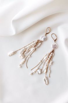 Elevate your bridal ensemble with these exquisite long dangly boho luxury earrings. Handcrafted with meticulous care and quality materials, these earrings feature a stunning combination of 14k filled gold chain and a curated mix of freshwater pearls, ensuring a unique and timeless design. The graceful movement of the chains adds a touch of sophistication, the perfect stylish wedding jewelry for your special day.   The careful craftsmanship ensures both beauty and durability, making them a cheris Dangling Beads Bridal Earrings For Celebration, Bridal Dangle Earrings With Dangling Beads, Bridal Earrings With Dangling Beads For Celebration, Silver Jewelry With Dangling Charms For Wedding, Pearl Chandelier Earrings With Dangling Beads For Wedding, Dangling Beads Bridal Earrings For Wedding, Elegant Long Drop Chandelier Earrings With Dangling Charms, Wedding Pearl Chandelier Earrings With Dangling Beads, Gold Bohemian Chandelier Earrings For Wedding