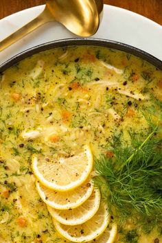 a bowl of soup with lemons and herbs