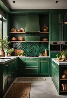 a kitchen with green cupboards and white counter tops in the center is filled with pots, pans, and other items