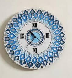 a blue and white clock on the wall with roman numerals in arabic style