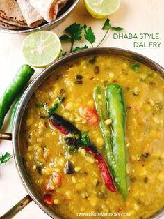 a pan filled with food and garnished with cilantro, green beans and lime