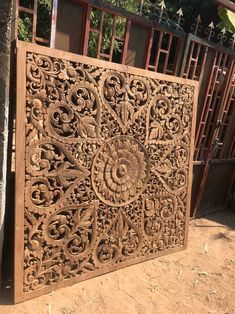 an intricately carved wooden panel in front of a gate