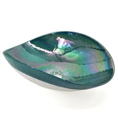 a green and blue bowl sitting on top of a white table