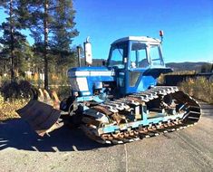 a blue tractor parked on the side of a road