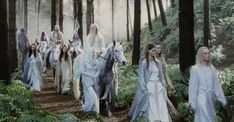 a group of people dressed in white walking through the woods with horses and men behind them