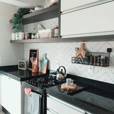 a stove top oven sitting inside of a kitchen next to a counter with pots and pans on it