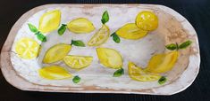 a white plate topped with lemon slices and green leaves