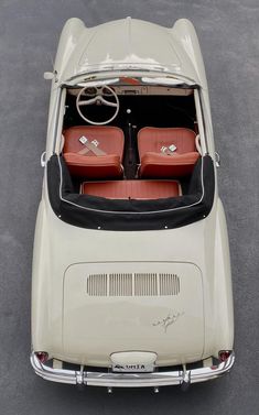 an old white car with red seats in the back seat is shown from above, looking down