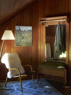 a chair and lamp in a room with wood paneling