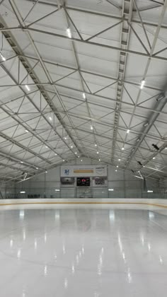 an indoor ice rink with lights on the ceiling