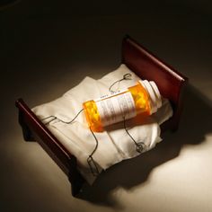 an empty bottle sitting on top of a white sheet in a small wooden bed frame