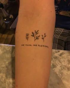 a person with a tattoo on their arm that says, no rain, no flowers