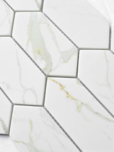 white marble tile with gold veining on the edges and diagonal hexagon tiles