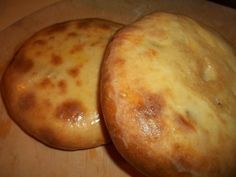 two round breads sitting on top of a cutting board