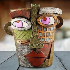 a cup with some kind of face painted on it's side and eyes in the middle