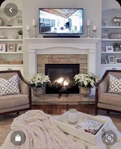 a living room with two couches and a fire place in the fireplace, surrounded by bookshelves