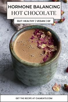 a cup filled with chocolate and garnished with red flowers on the side, in front of a text overlay that reads how to use for horme balancing hot chocolate