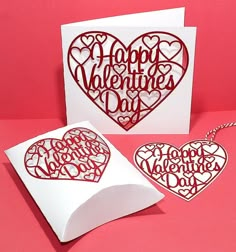 two valentine's day cards with hearts cut out of paper on a pink background