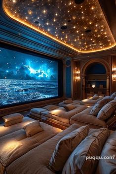 an image of a movie room setting with couches and large screen on the wall