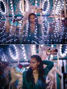 a woman standing in front of a carousel with lights all around her and on top of the carousel